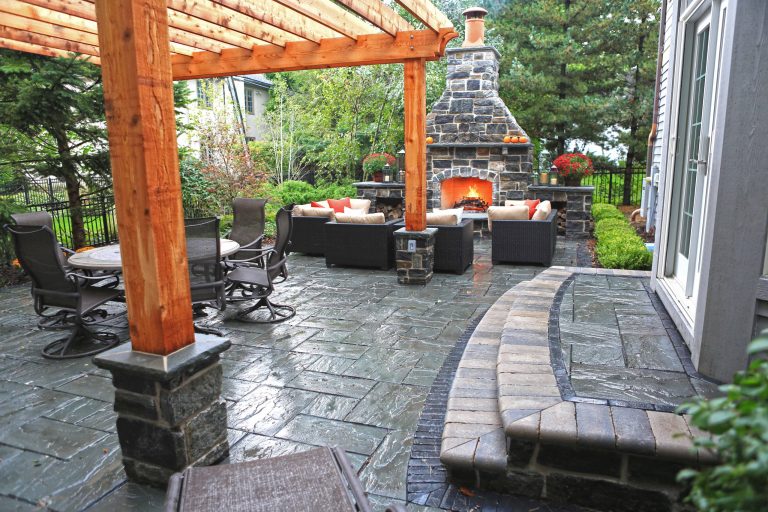 Inspiration for a large timeless backyard stamped concrete patio kitchen remodel in Chicago with a pergola