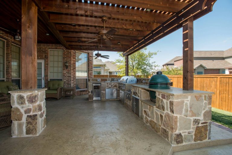 Inspiration for a large timeless backyard stamped concrete patio kitchen remodel in Dallas with a pergola