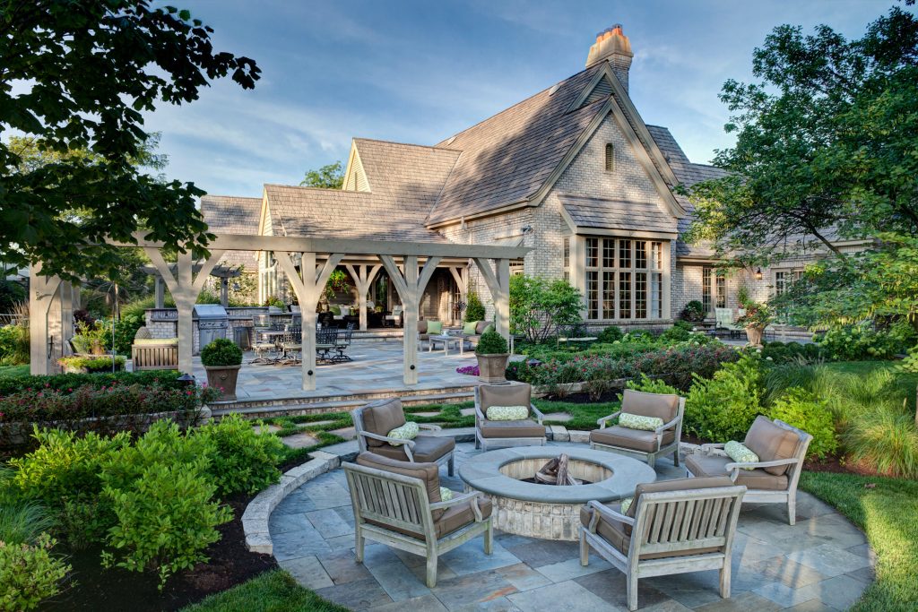 Inspiration for a large timeless backyard stone patio kitchen remodel in Chicago with a pergola