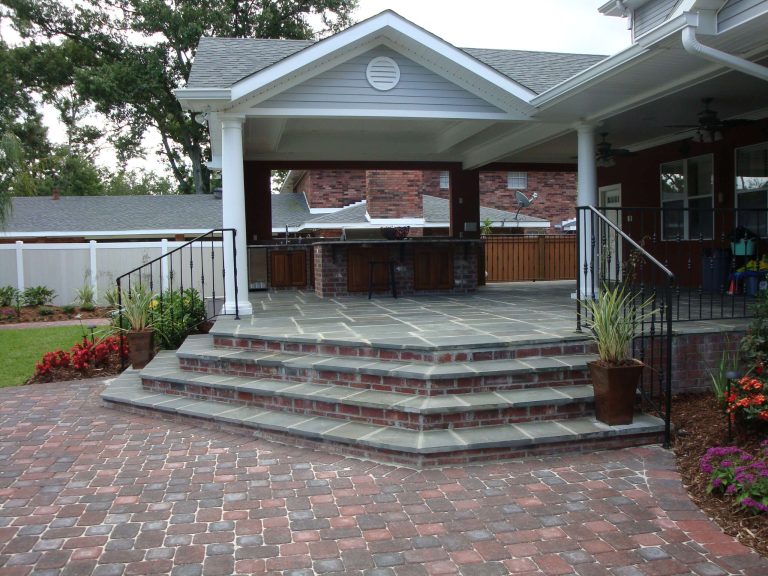 Inspiration for a large timeless backyard stone patio kitchen remodel in New Orleans with a roof extension