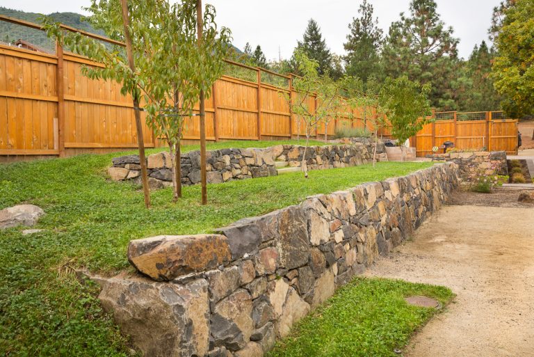 Inspiration for a large traditional full sun backyard gravel retaining wall landscape in Other.