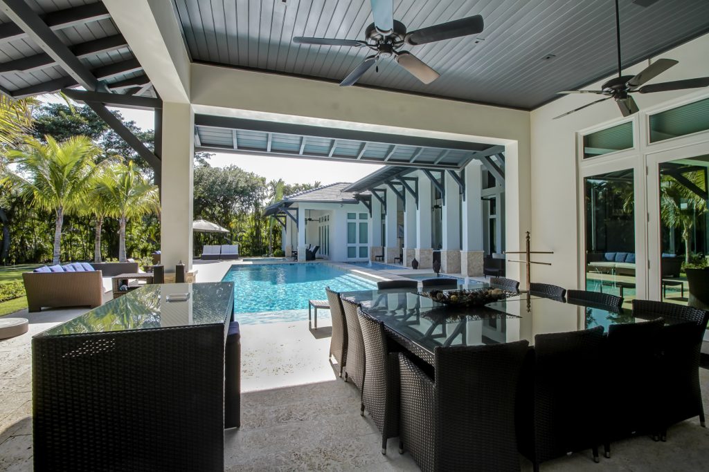 Inspiration for a large transitional backyard concrete paver patio kitchen remodel in Miami with a roof extension