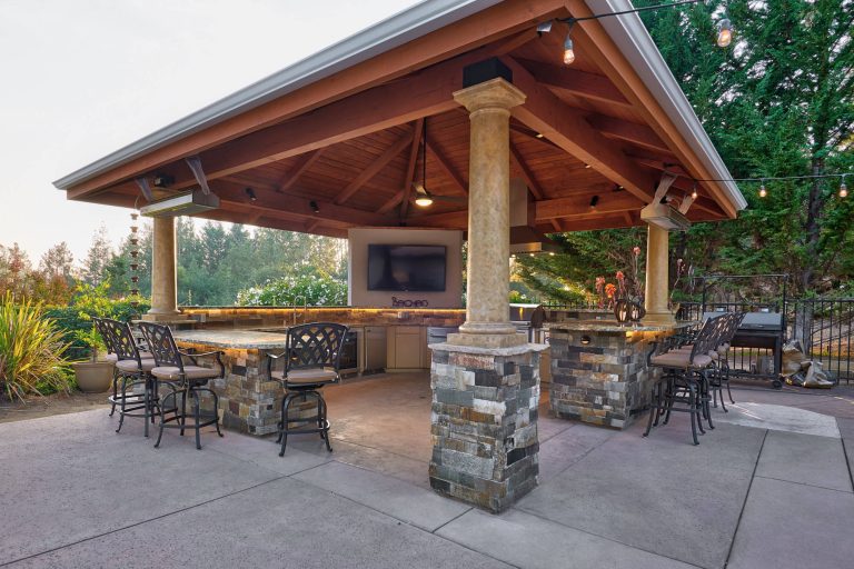 Inspiration for a large transitional backyard stamped concrete patio kitchen remodel in Other with a gazebo