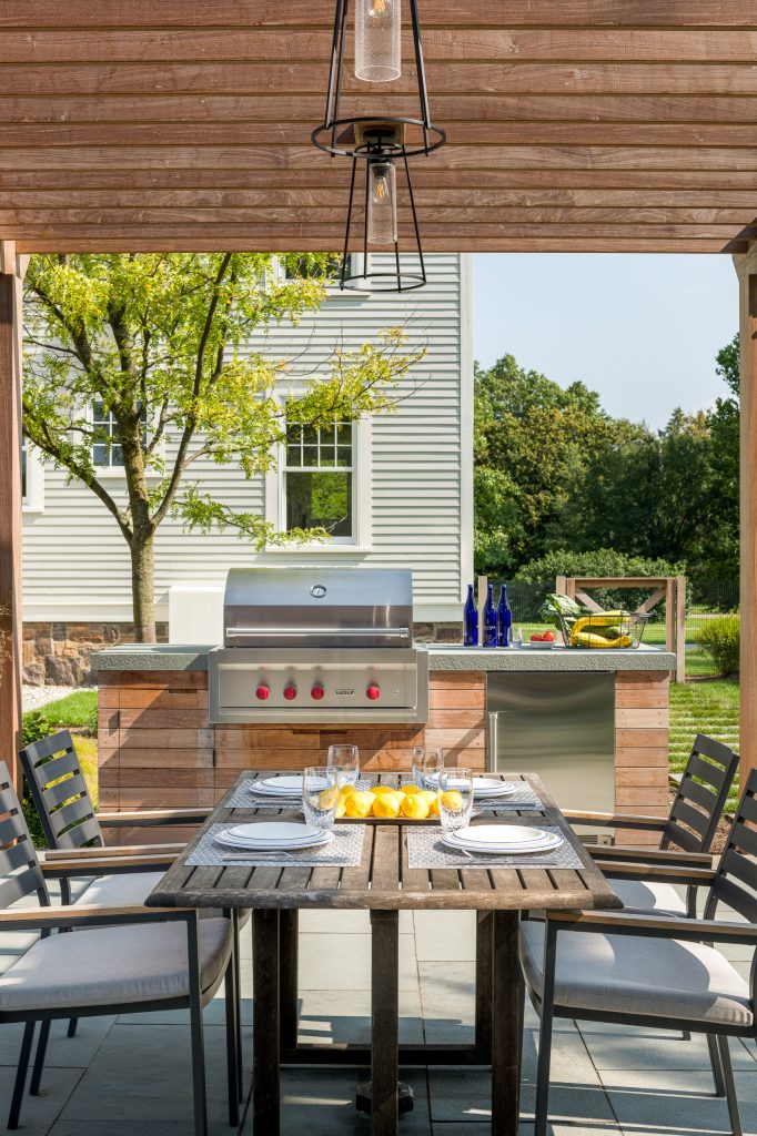 Inspiration for a large transitional backyard stone patio kitchen remodel in Burlington with a pergola