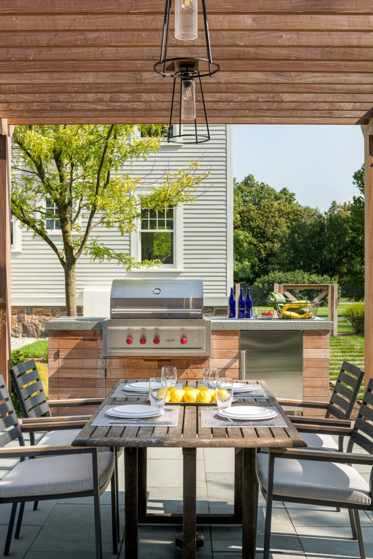 Inspiration for a large transitional backyard stone patio kitchen remodel in Burlington with a pergola