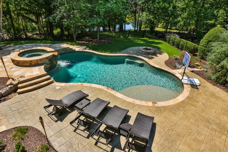 Inspiration for a large tropical backyard stamped concrete and custom-shaped natural pool fountain remodel in Atlanta