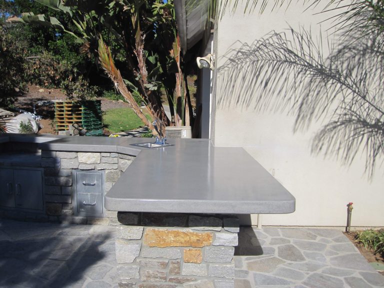 Inspiration for a large tropical backyard stone patio kitchen remodel in San Diego with no cover