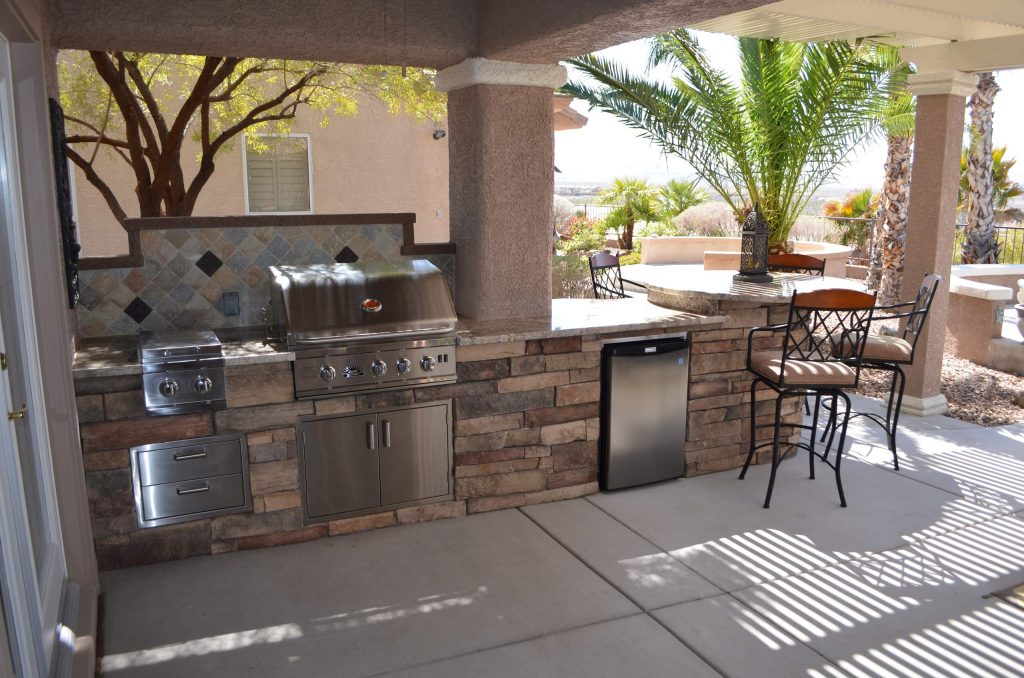 Inspiration for a mediterranean backyard stone patio kitchen remodel in Las Vegas