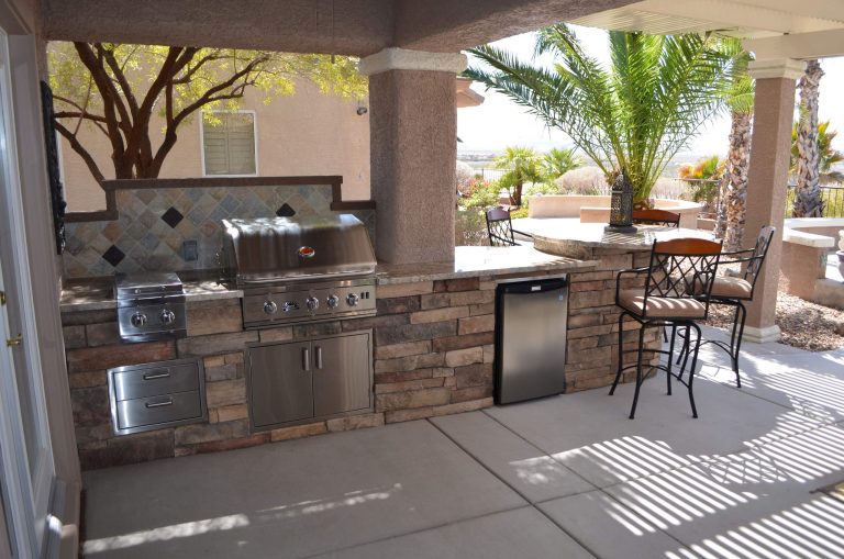 Inspiration for a mediterranean backyard stone patio kitchen remodel in Las Vegas