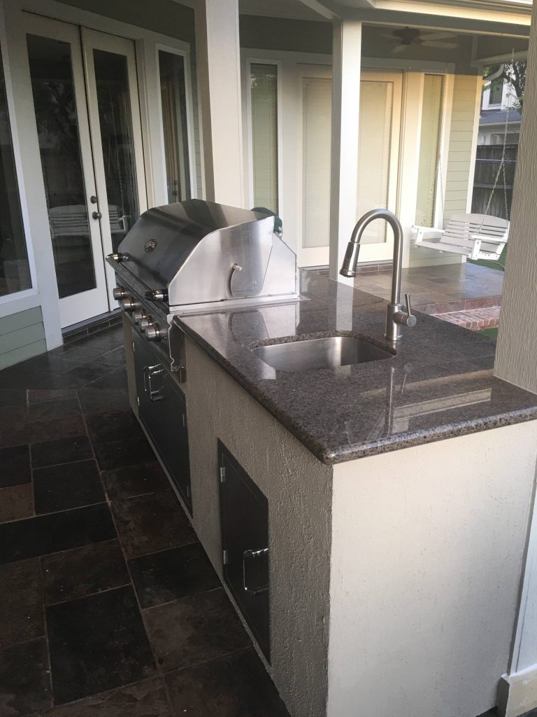 Inspiration for a mid-sized backyard stamped concrete patio kitchen remodel in Houston with a roof extension