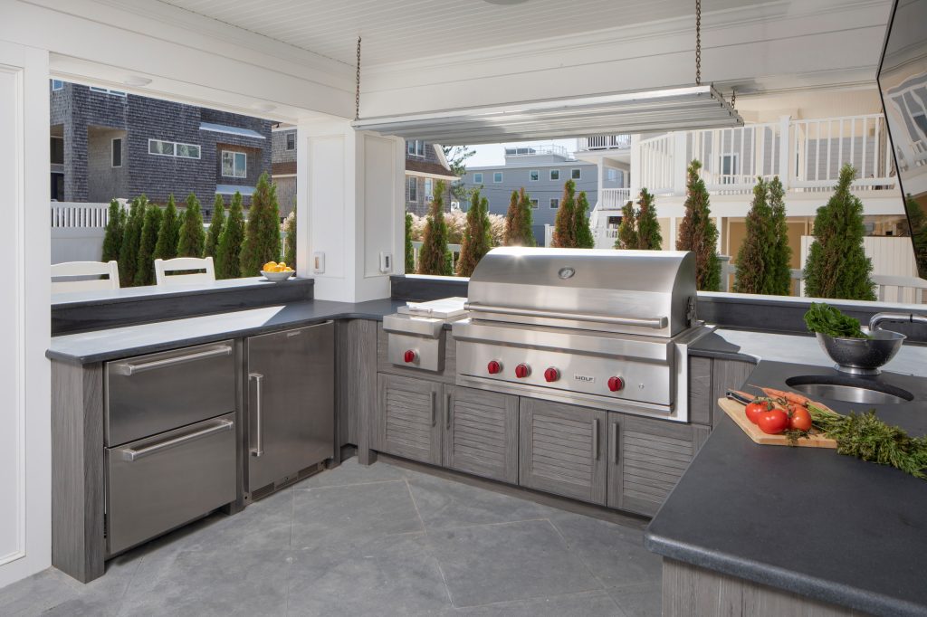 Inspiration for a mid-sized coastal backyard concrete paver patio kitchen remodel in New York with a roof extension