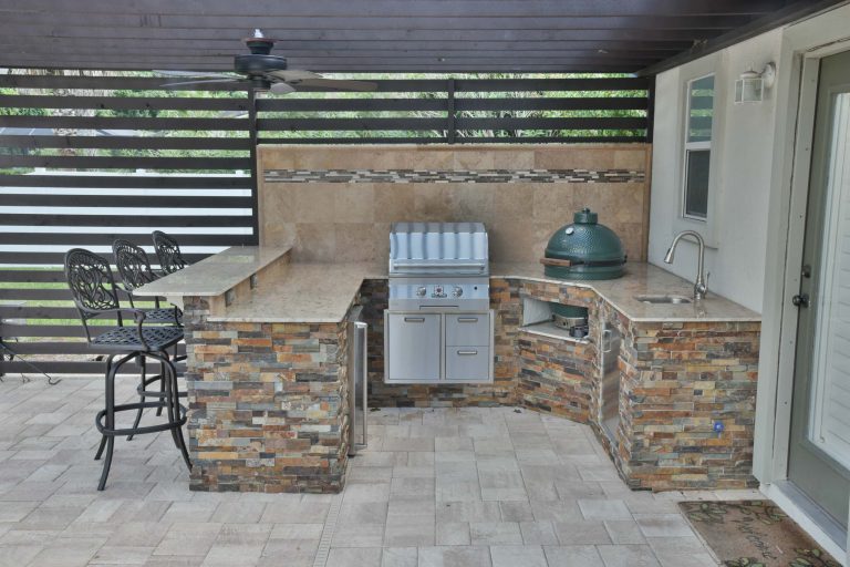 Inspiration for a mid-sized contemporary backyard concrete paver patio kitchen remodel in Jacksonville with a pergola