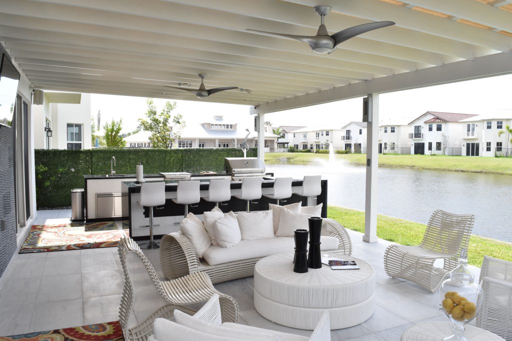 Inspiration for a mid-sized contemporary backyard stone patio kitchen remodel in Miami with an awning