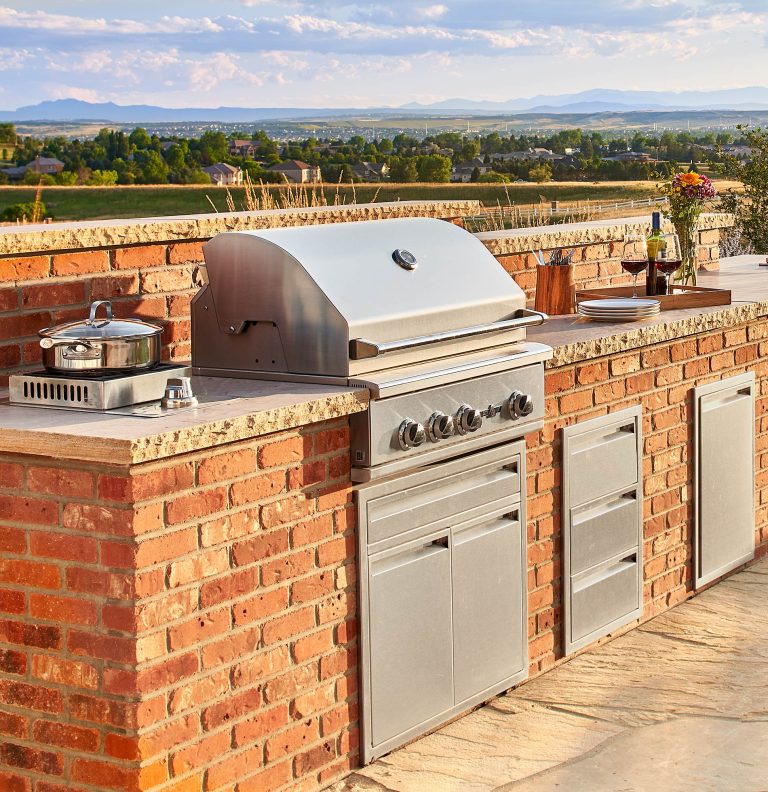 Inspiration for a mid-sized country backyard stone patio kitchen remodel in Denver with no cover