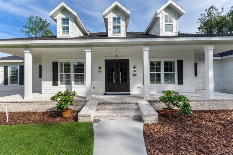 Inspiration for a mid-sized country brick porch remodel in Other with a roof extension by Hartley Brothers Inc. | Outdoor Photos | Porch | Landscaping | Landscape Design | Outdoor Living Space | Porch Design Ideas | Outdoor Living Space Ideas | Backyard Design