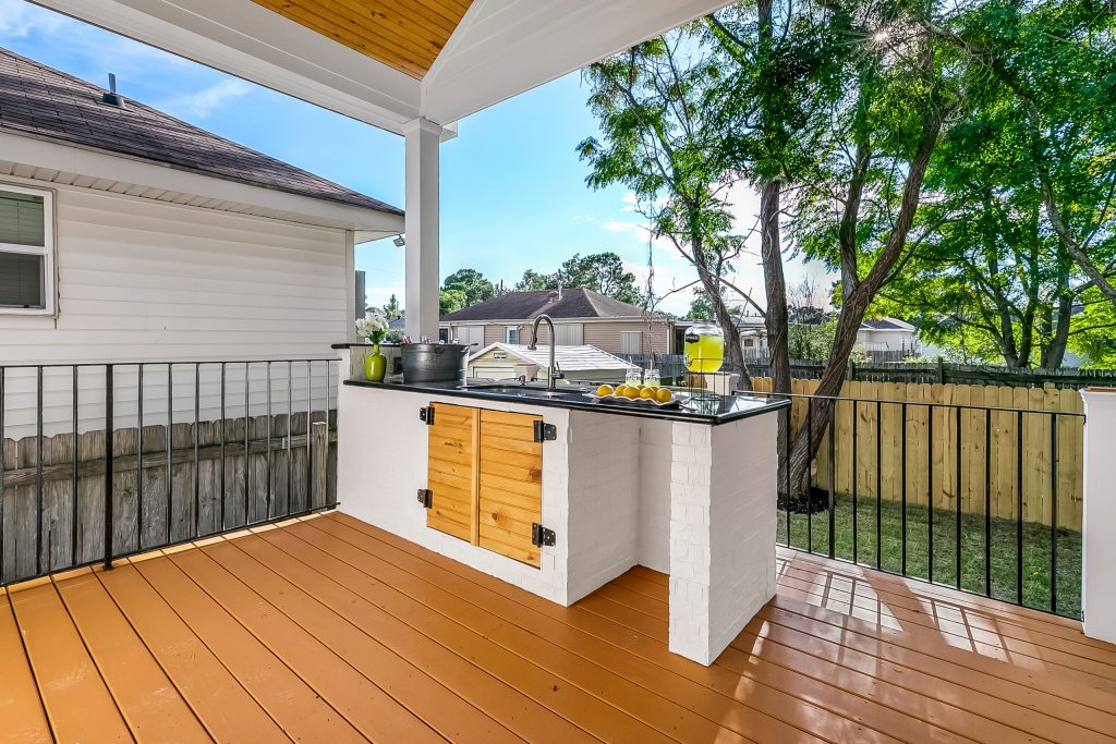 Inspiration for a mid-sized mid-century modern backyard outdoor kitchen deck remodel in New Orleans with a roof extension