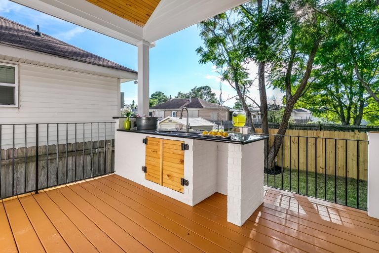 Inspiration for a mid-sized mid-century modern backyard outdoor kitchen deck remodel in New Orleans with a roof extension