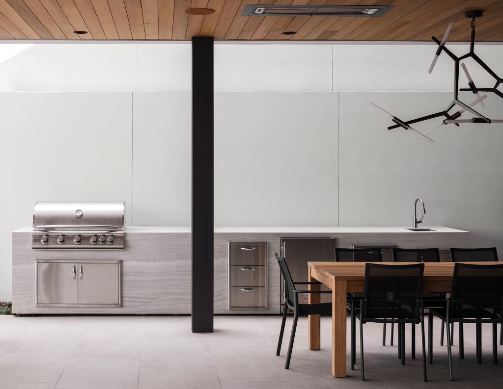 Inspiration for a mid-sized modern backyard ground level outdoor kitchen deck remodel in Orange County with a roof extension