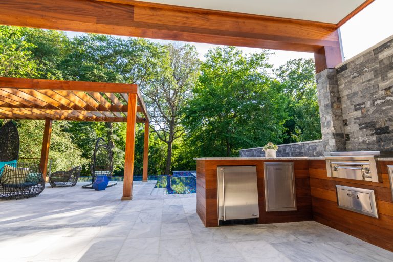 Inspiration for a mid-sized modern backyard stone patio kitchen remodel in Raleigh with a pergola