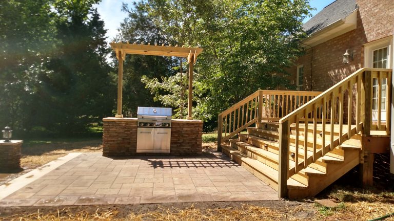 Inspiration for a mid-sized rustic backyard concrete paver patio kitchen remodel in Raleigh with a pergola