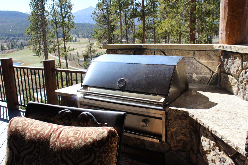 Inspiration for a mid-sized rustic backyard outdoor kitchen deck remodel in Denver with a roof extension
