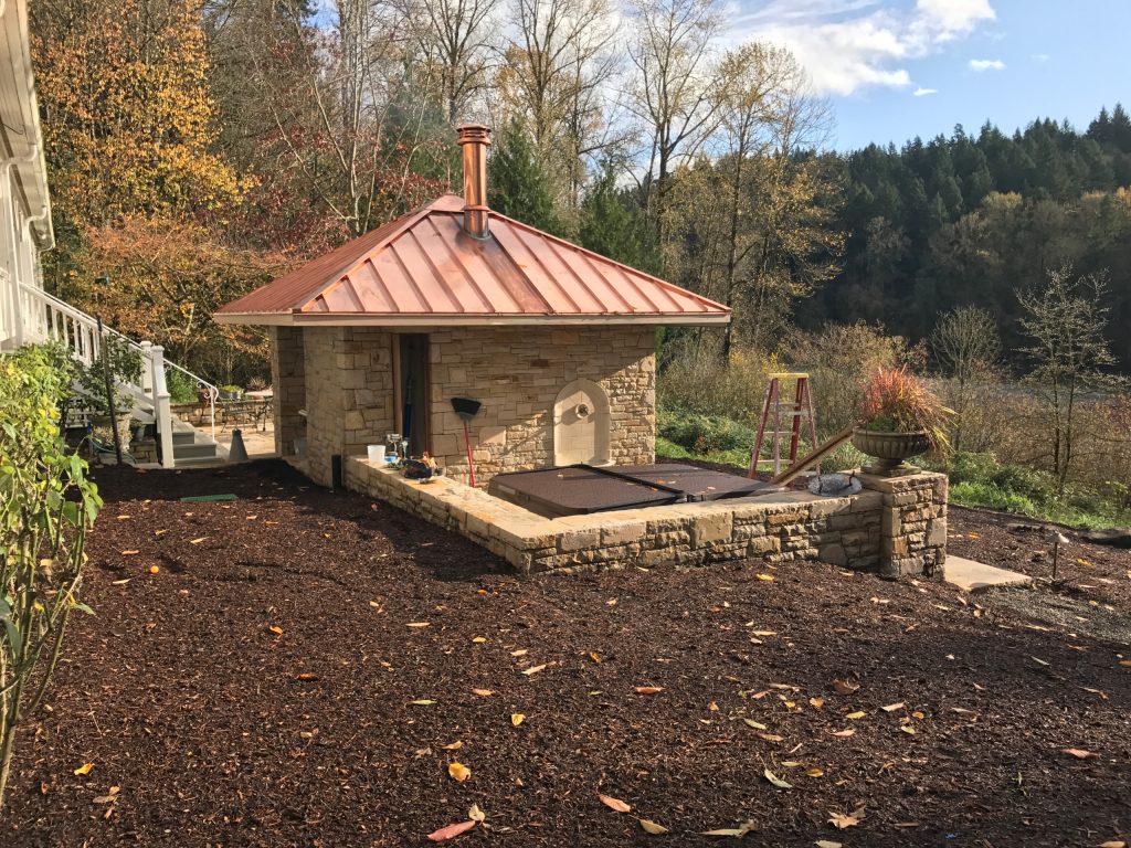 Inspiration for a mid-sized rustic backyard stone patio kitchen remodel in Portland with a gazebo