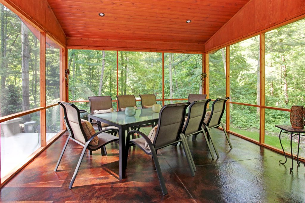 Inspiration for a mid-sized rustic concrete screened-in back porch remodel in Grand Rapids with a roof extension by JPD Construction, Inc. | Outdoor Photos | Porch | Landscaping | Landscape Design | Outdoor Living Space | Porch Design Ideas | Outdoor Living Space Ideas | Backyard Design