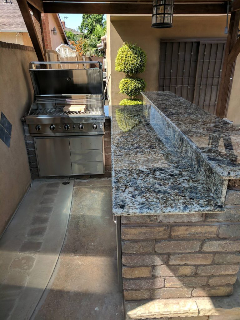 Inspiration for a mid-sized timeless backyard concrete patio kitchen remodel in Los Angeles with a pergola
