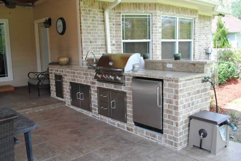 Inspiration for a mid-sized timeless backyard stamped concrete patio kitchen remodel in Houston with a roof extension