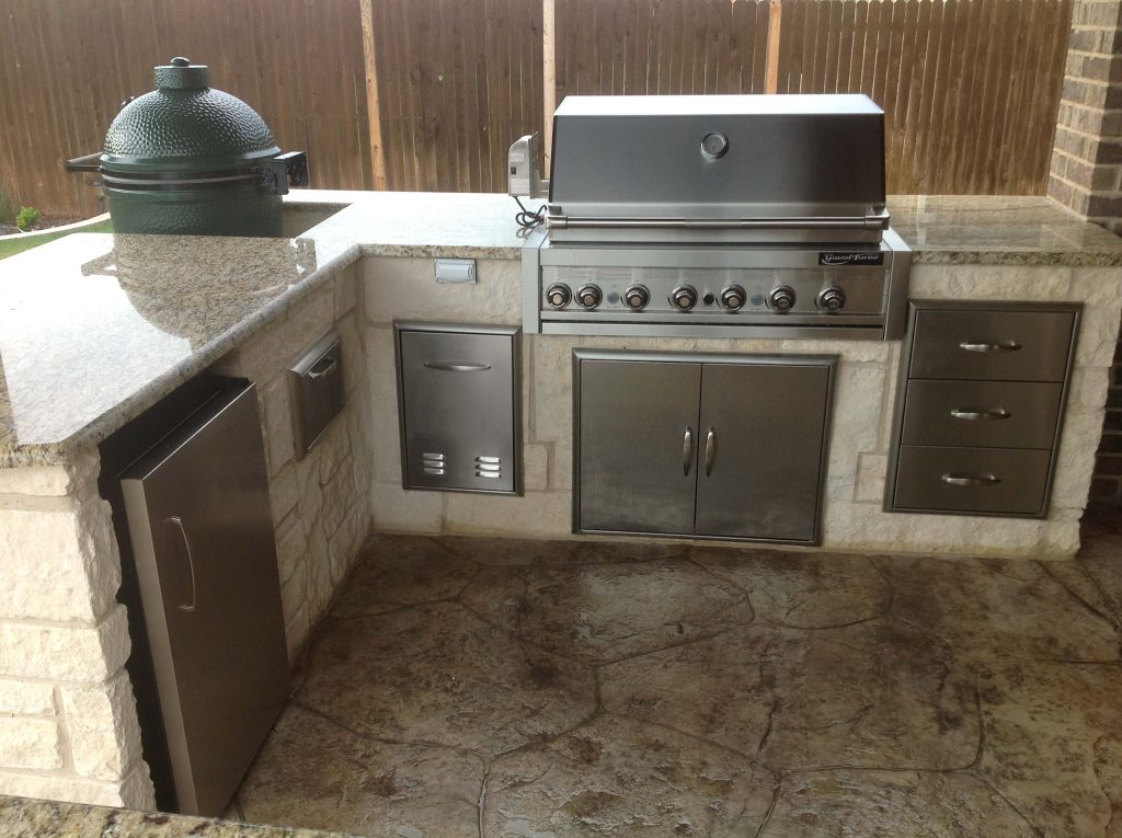 Inspiration for a mid-sized timeless backyard stamped concrete patio kitchen remodel with a roof extension
