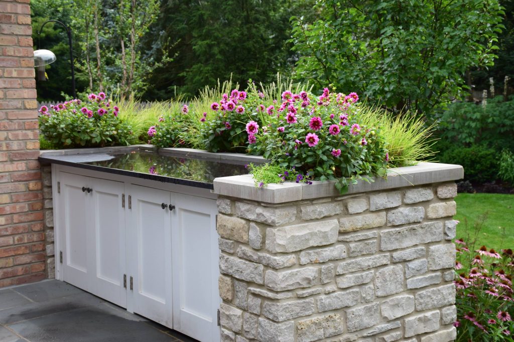 Inspiration for a mid-sized timeless backyard stone patio kitchen remodel in Chicago with no cover