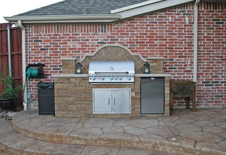 Inspiration for a mid-sized timeless backyard stone patio kitchen remodel in Dallas with no cover
