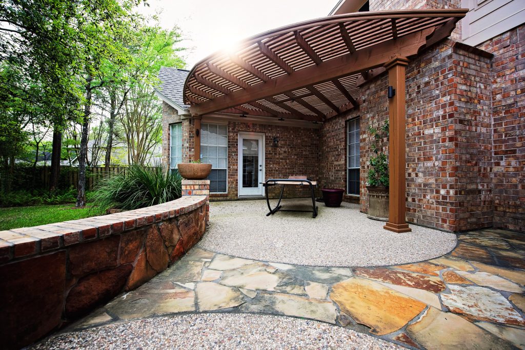 Inspiration for a mid-sized timeless backyard stone patio kitchen remodel in Houston with a pergola