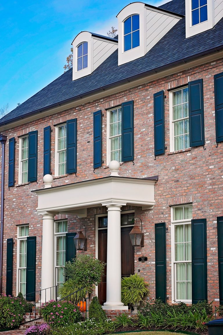 Inspiration for a mid-sized timeless brick front porch remodel in New Orleans with a roof extension by Copper Works Lighting | Outdoor Photos | Porch | Landscaping | Landscape Design | Outdoor Living Space | Porch Design Ideas | Outdoor Living Space Ideas | Backyard Design