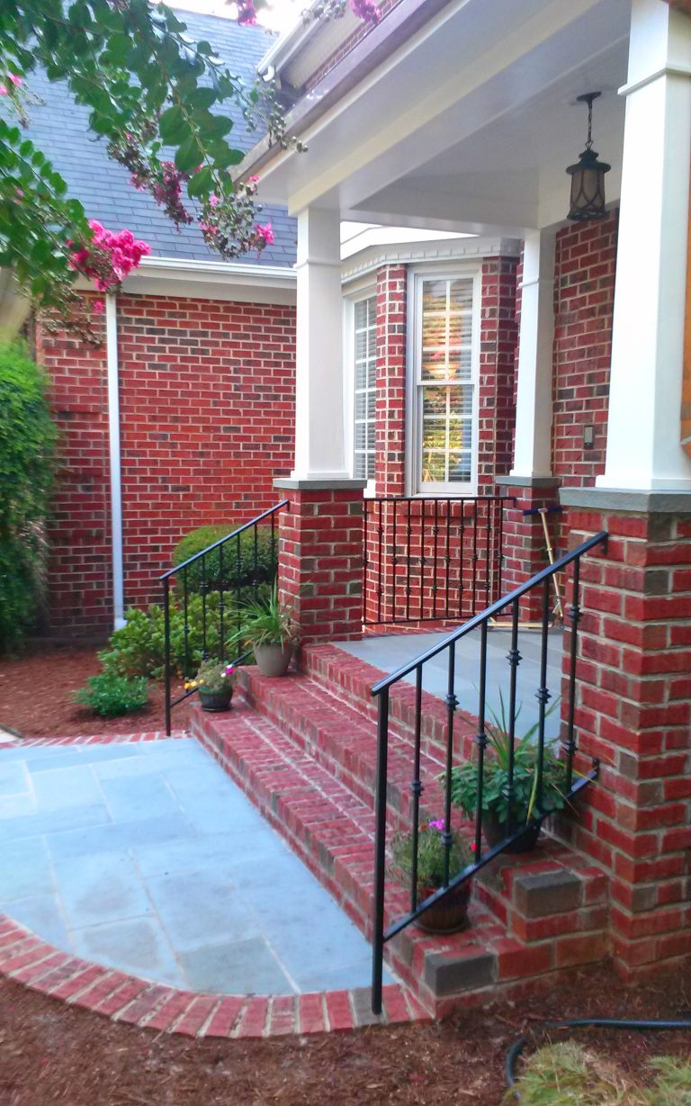 Inspiration for a mid-sized timeless brick front porch remodel in Raleigh with a roof extension by PHILLIPJEFFERSONDESIGN LLC | Outdoor Photos | Porch | Landscaping | Landscape Design | Outdoor Living Space | Porch Design Ideas | Outdoor Living Space Ideas | Backyard Design