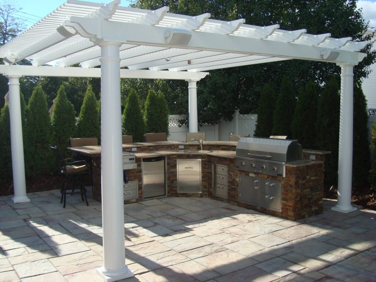 Inspiration for a mid-sized transitional backyard stamped concrete patio kitchen remodel in New York with a pergola