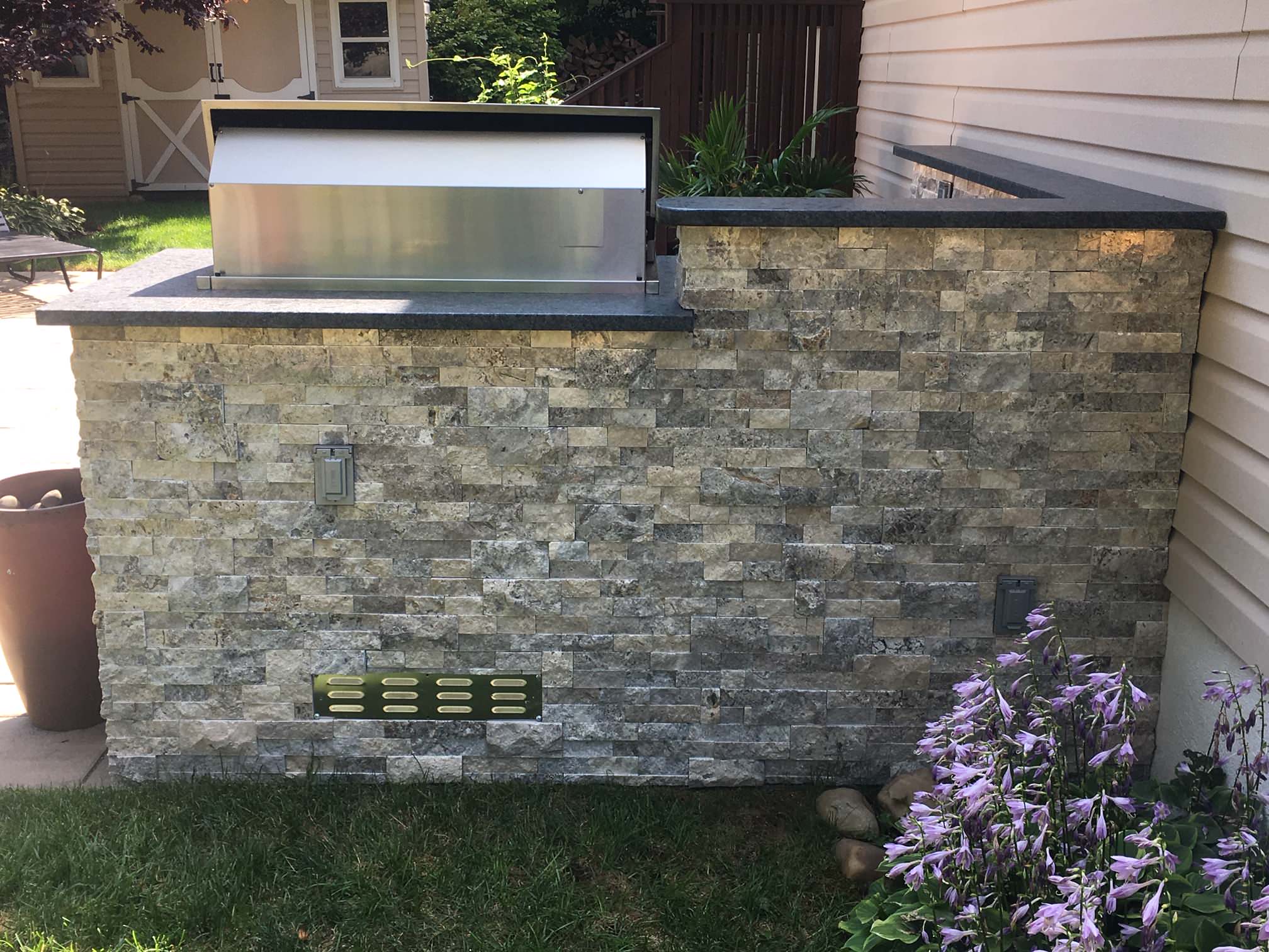 Inspiration for a mid-sized transitional side yard stone patio kitchen remodel in New York with no cover
