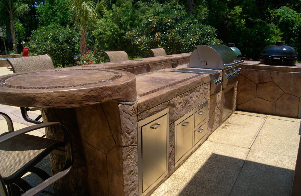 Inspiration for a mid-sized tropical backyard stamped concrete patio kitchen remodel in Houston with no cover