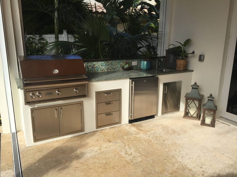 Inspiration for a mid-sized tropical backyard stone patio kitchen remodel in Miami with a roof extension