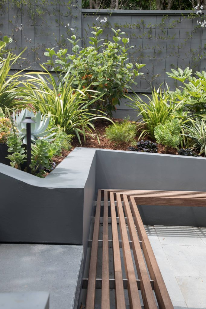 Inspiration for a mid-sized contemporary partial sun backyard stone formal garden in San Francisco with a fire pit.