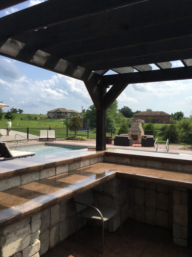 Inspiration for a modern backyard brick patio kitchen remodel in Other with a pergola