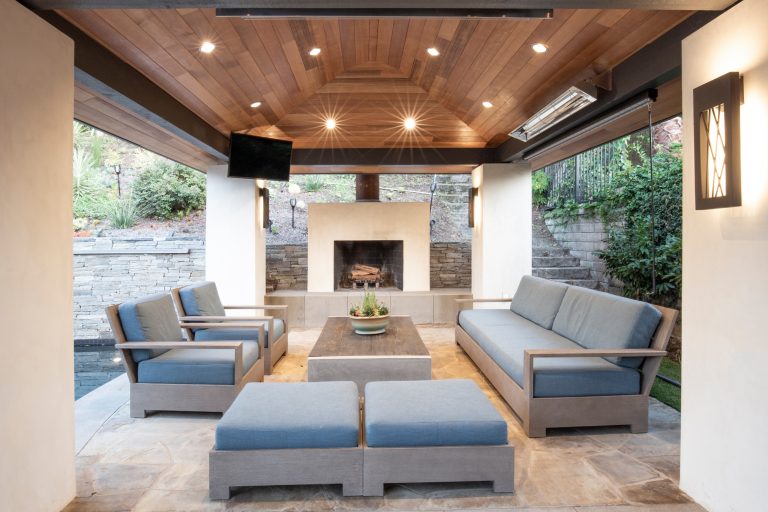 Inspiration for a modern backyard stone patio kitchen remodel in Orange County with a pergola