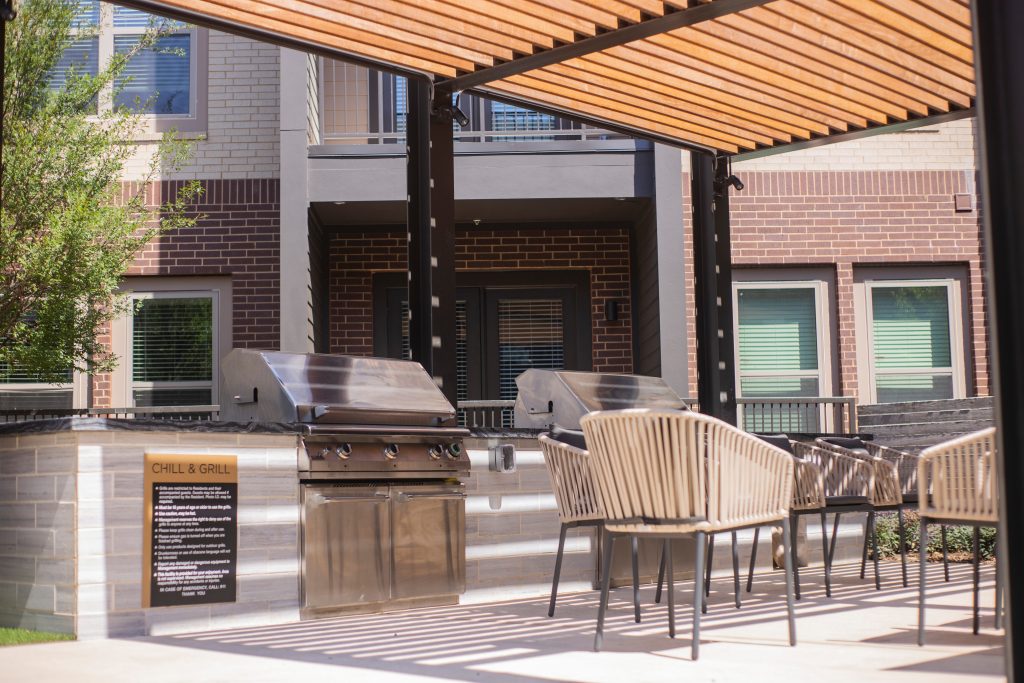 Inspiration for a modern courtyard concrete patio kitchen remodel in Dallas with a pergola