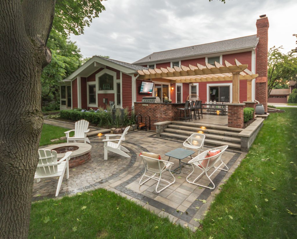 Inspiration for a small craftsman backyard brick patio kitchen remodel in Detroit with a pergola