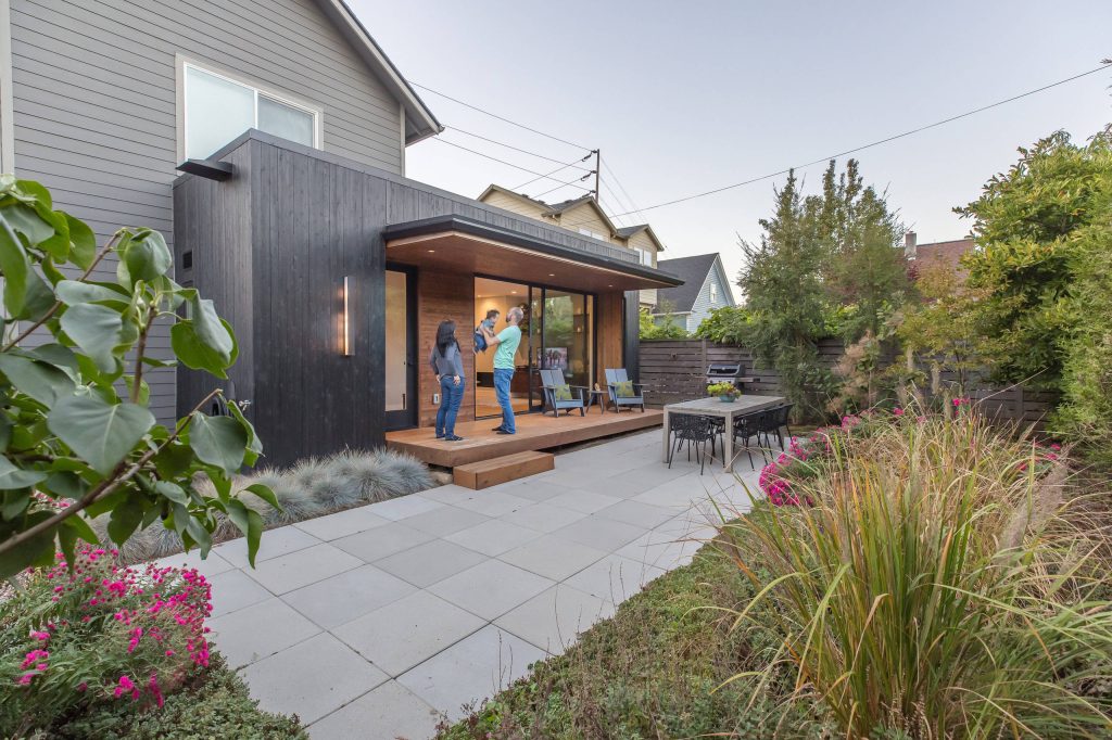 Inspiration for a small modern courtyard concrete paver patio kitchen remodel in Portland with a roof extension