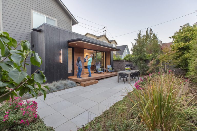 Inspiration for a small modern courtyard concrete paver patio kitchen remodel in Portland with a roof extension