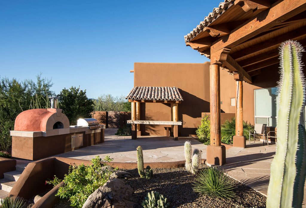 Inspiration for a small southwestern backyard stone patio kitchen remodel in Phoenix