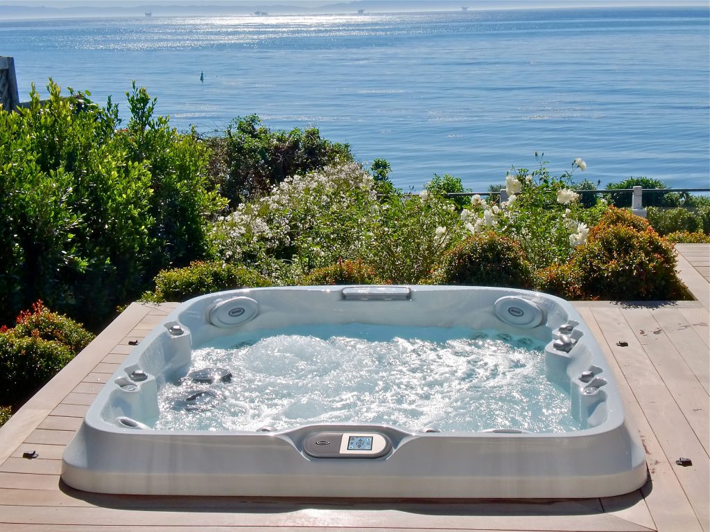 Inspiration for a small tropical backyard rectangular aboveground hot tub remodel in Tampa with decking