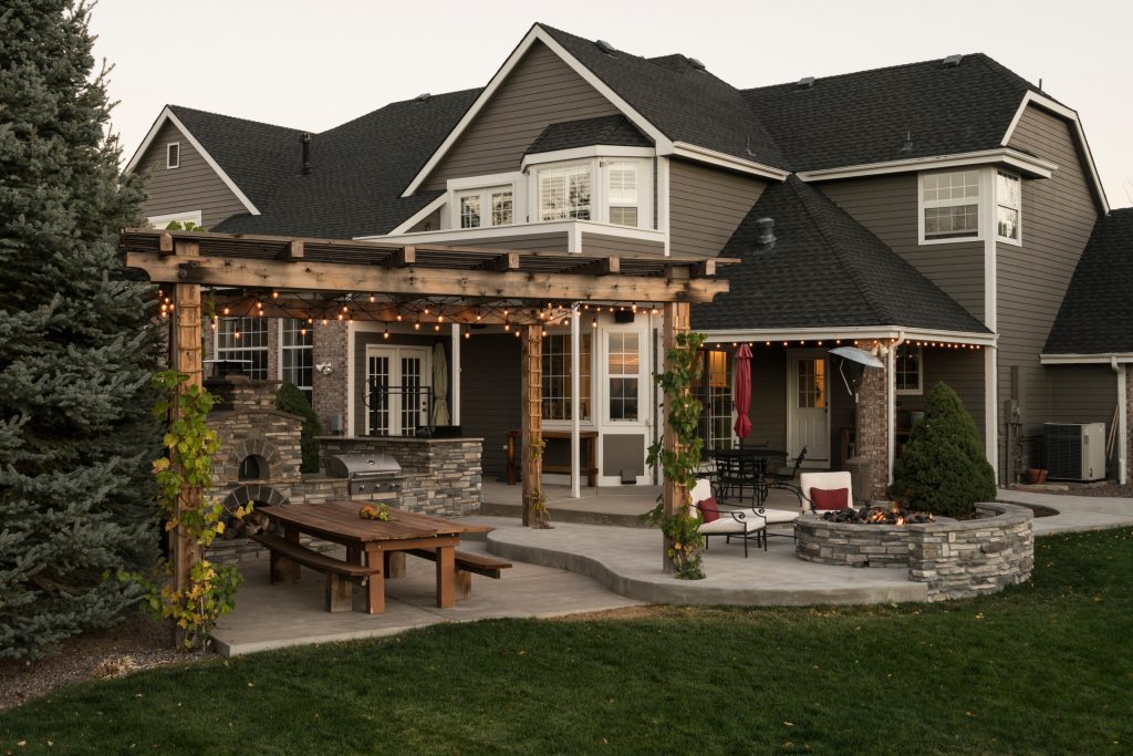 Inspiration for a timeless backyard concrete patio kitchen remodel in Denver with a pergola