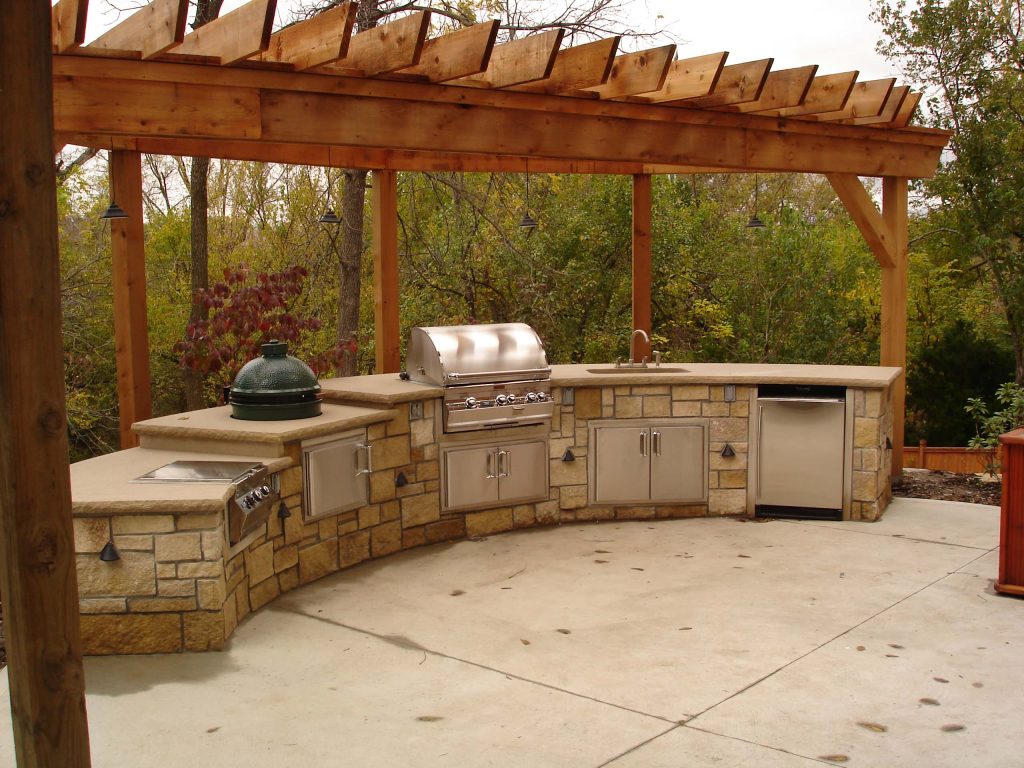 Inspiration for a timeless backyard concrete patio kitchen remodel in Kansas City with a pergola